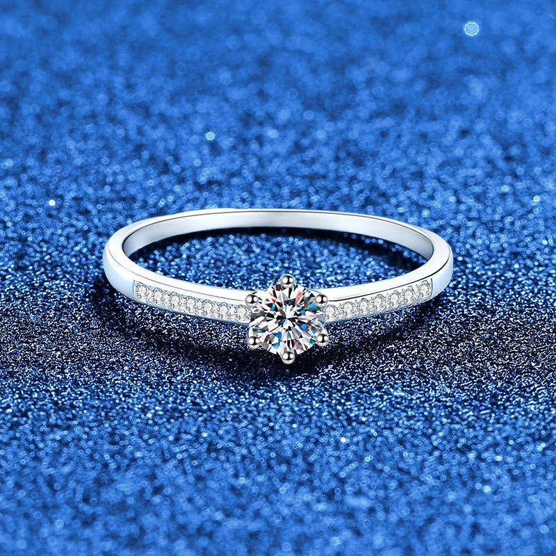 Anel solitário de moissanite em prata 925 fotografado sobre fundo azul brilhante